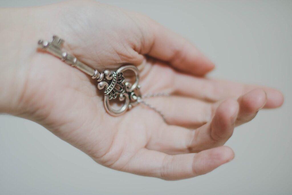 person holding silver colored skeleton key in article missing from the secret