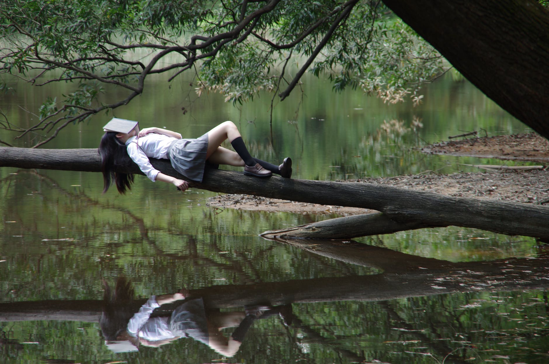 woman lying on tree near water. Illustrated breathing easy when maximal impact is not available.